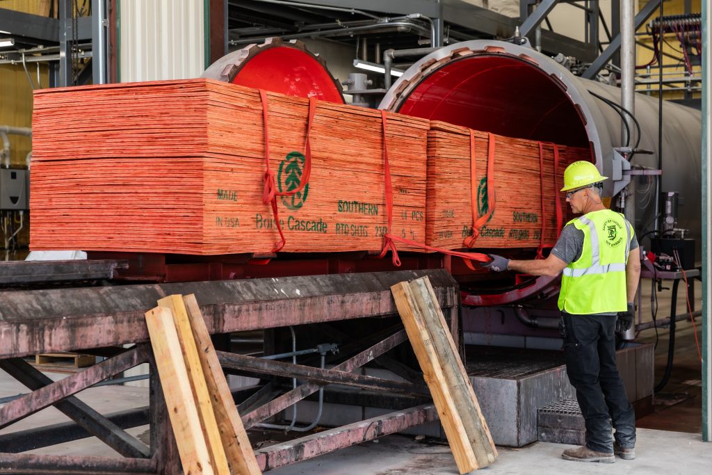 Boise Cascade plywood exiting a Hoover fire-retardant treatment cylinder, ensuring enhanced fire retardancy for construction projects.