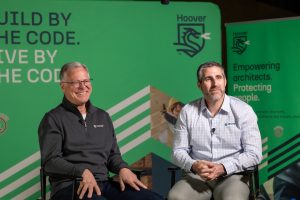 Hoover Treated Wood Products' experts, Dr. Dave Bueche and Chris Athari, discussing fire-retardant-treated wood (FRTW) solutions for safer structures, with Hoover branding in the background.